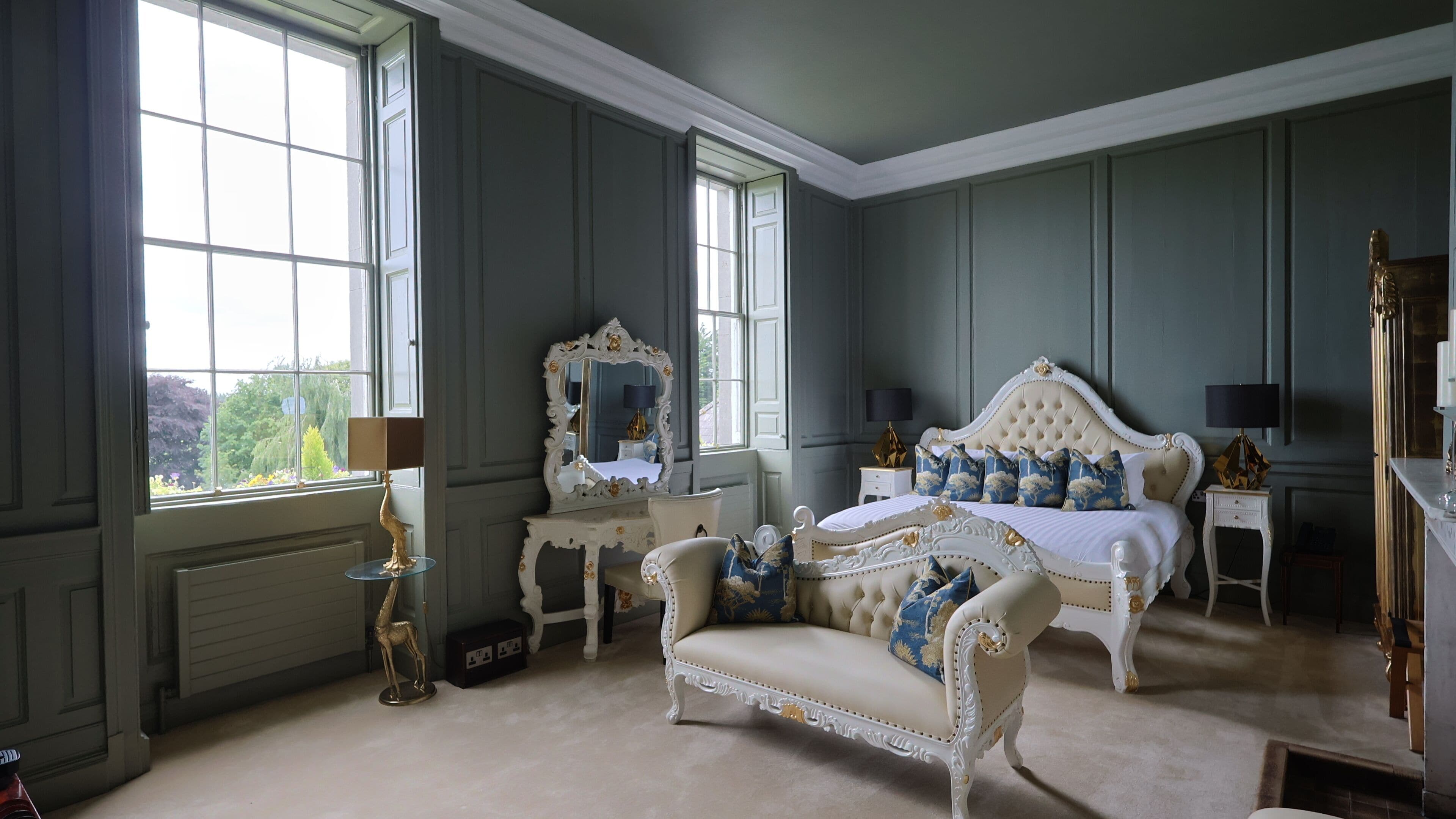 A bedroom with a large bed, a chair, a dresser, and a mirror.