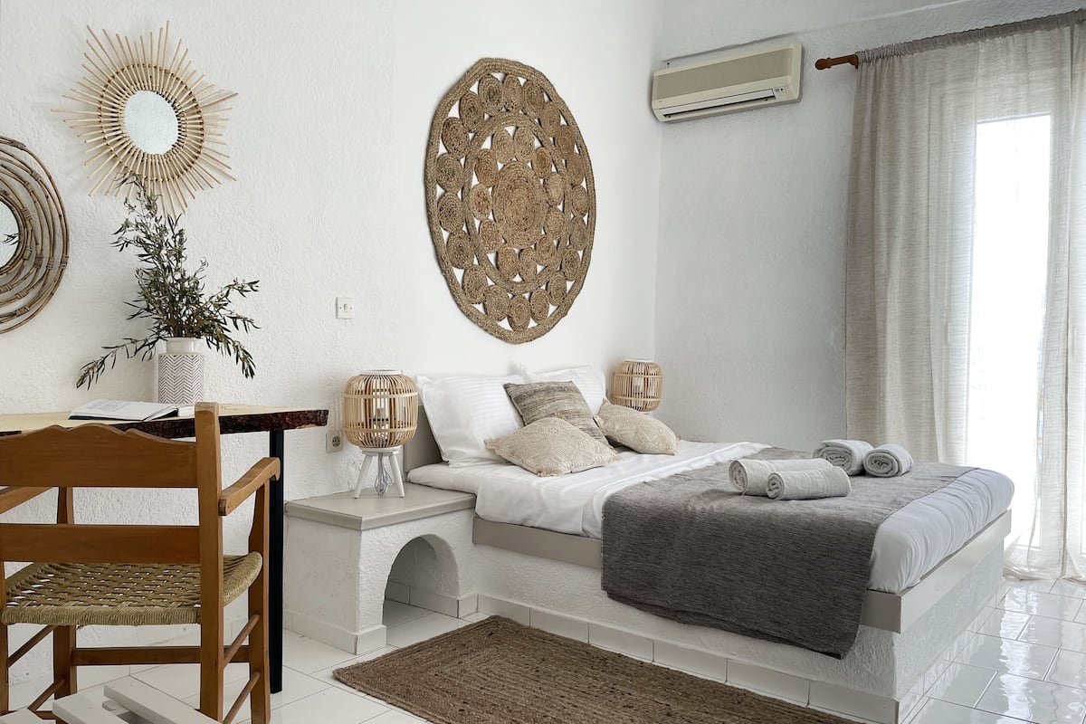 Ein Schlafzimmer mit einem Bett, Nachttischen, einem Sessel, einem Teppich und Wanddekoration.