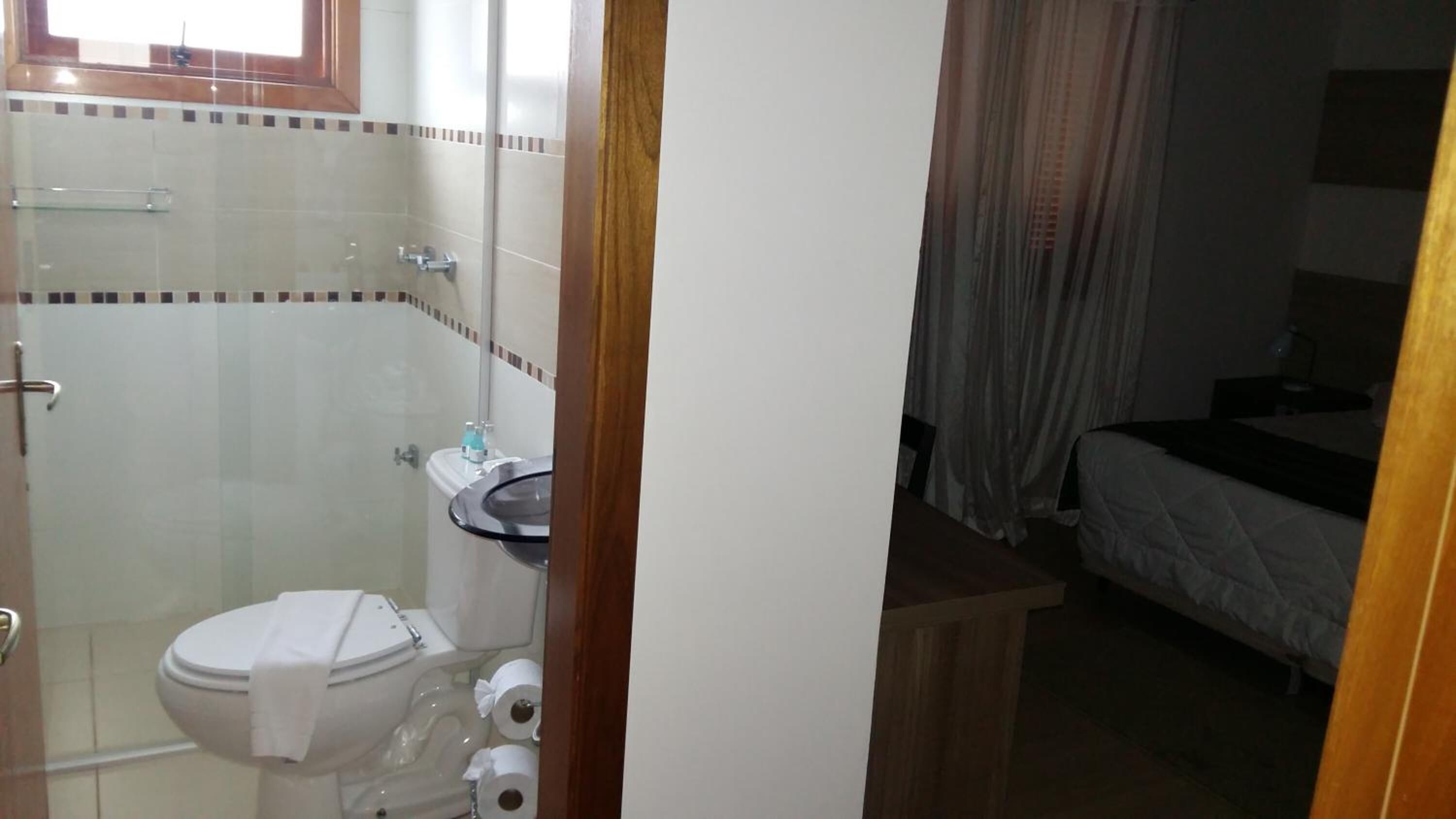 Un baño con inodoro, cabina de ducha de vidrio y lavamanos.