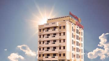 A multi-story hotel with a prominent sign reading 'Meenakshi Sunshine.'