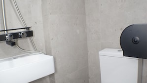 A small bathroom with a white sink, a toilet, and a shower. - Tung Wo Guest House (Kowloon)