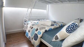 A bunk bed with a ladder, a blue and white patterned bedspread, and a pillow with a polka dot design. - Tung Wo Guest House (Kowloon)