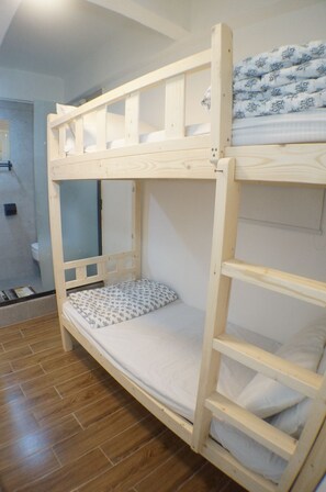 Letto a castello con struttura in legno e biancheria da letto bianca.