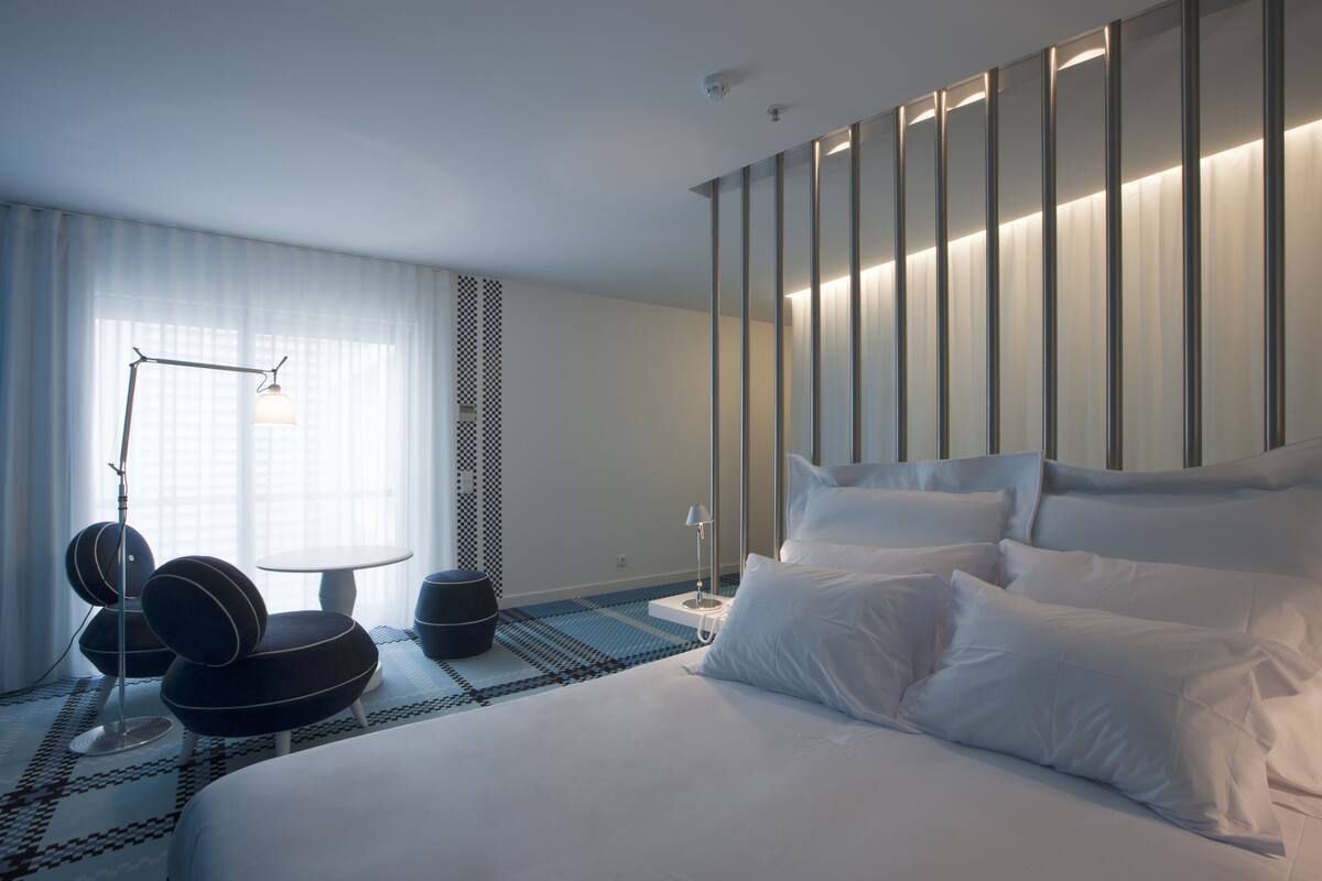 Moderni hotellihuone, jossa on suuri sänky, työpöytä ja tuoli.
