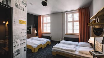 Une chambre d’hôtel avec deux lits, une carte accrochée au mur et une fenêtre avec des rideaux.