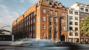 A multi-story building with a prominent entrance and a sign indicating it is a hotel. - Superbude St. Pauli (Hamburg)