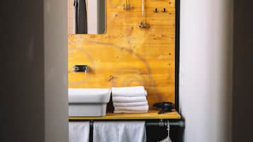 A modern bathroom with a wooden vanity, a sink, and a mirror.