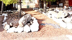 A rustic building with a stone facade, surrounded by trees and a gravel path. - Canyon Motel and RV Park (Williams)