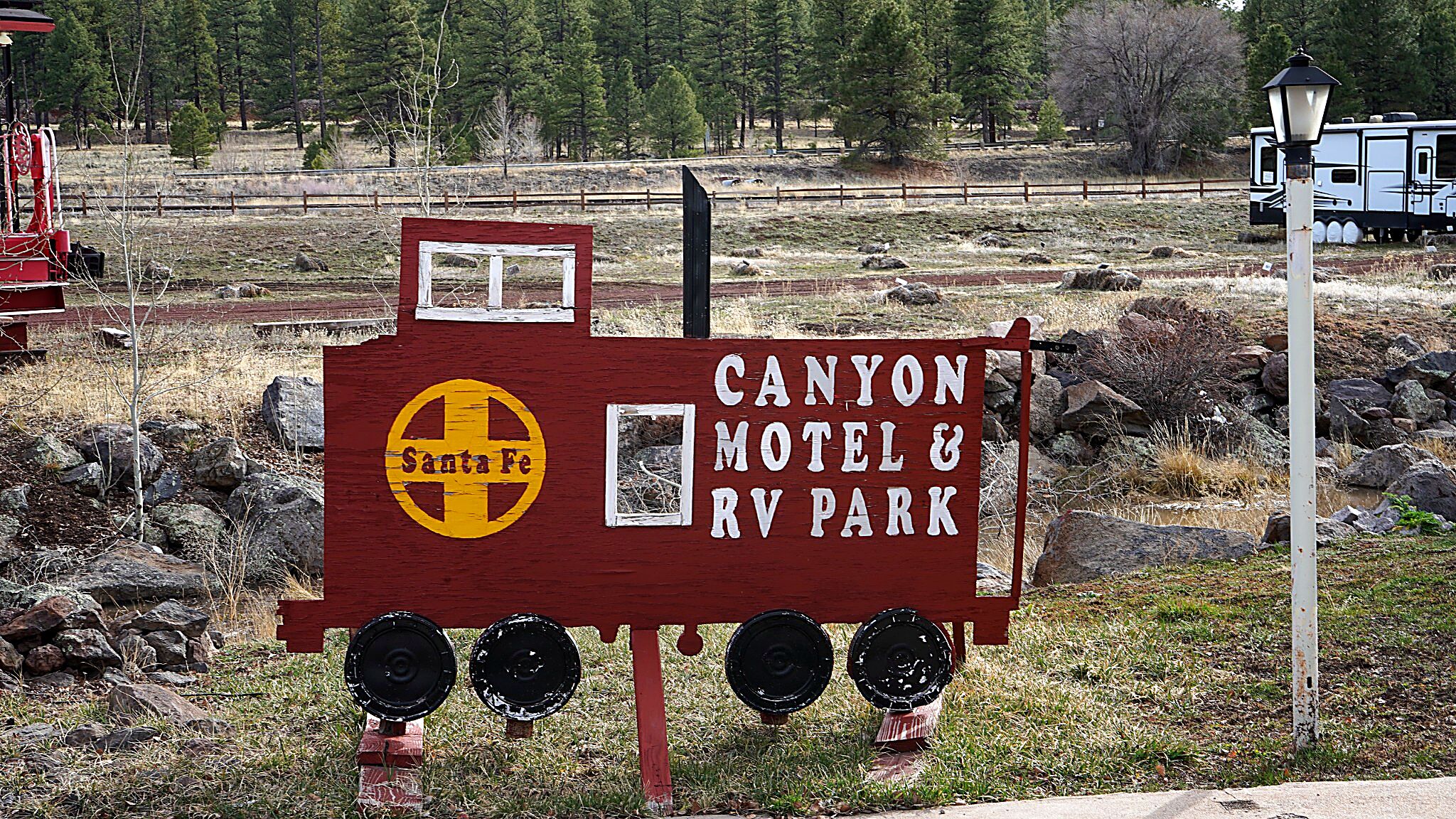 Schild für das Canyon Motel & RV Park mit dem Santa Fe Logo.