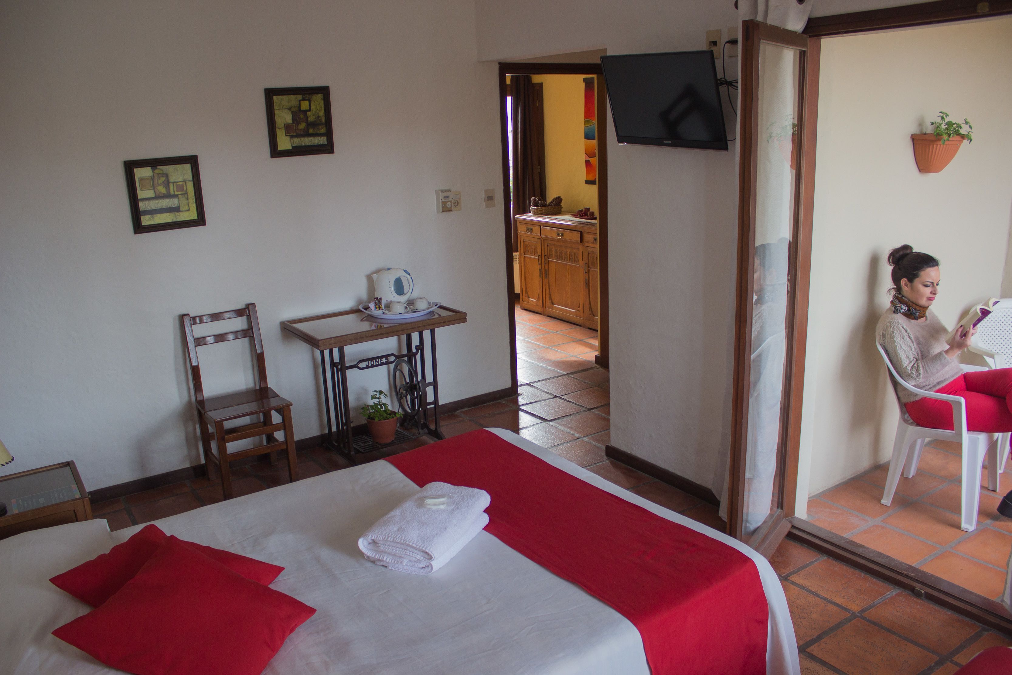 Una habitación de hotel con una cama, una silla, una mesita y un televisor.