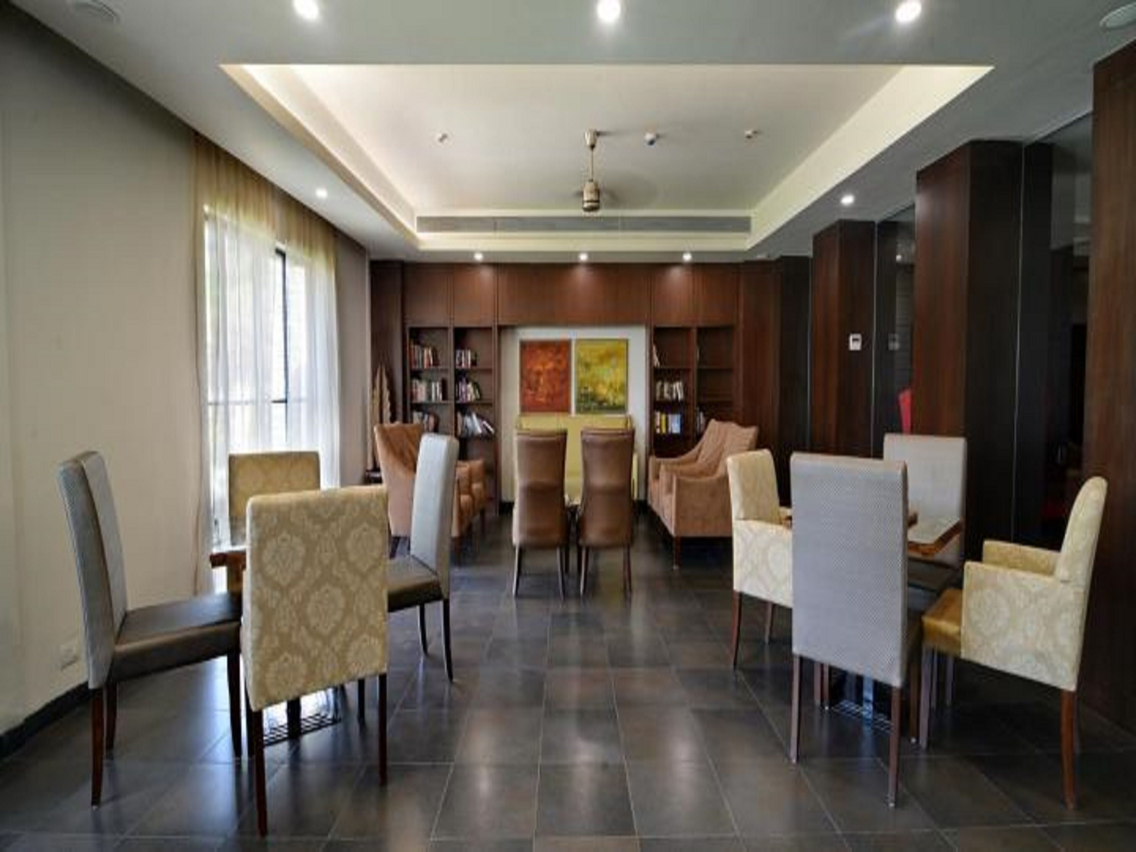 A spacious lobby with a high ceiling, recessed lighting, and a central seating area with multiple chairs and a sofa.