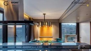 Una cocina moderna con una isla grande, electrodomésticos de acero inoxidable y vistas al exterior.