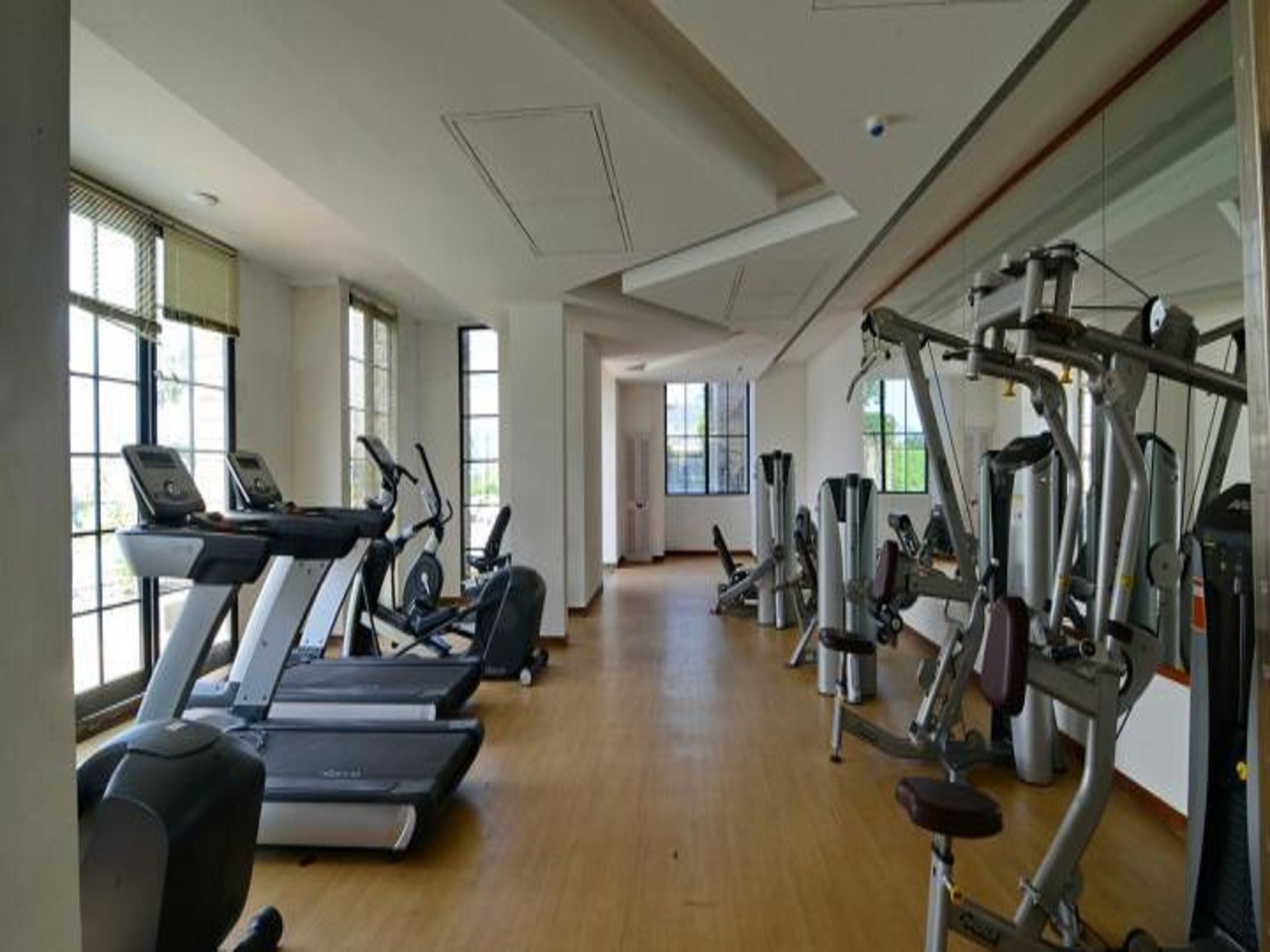 Ein Fitnessstudio mit Laufbändern, Crosstrainern und Gewichten.