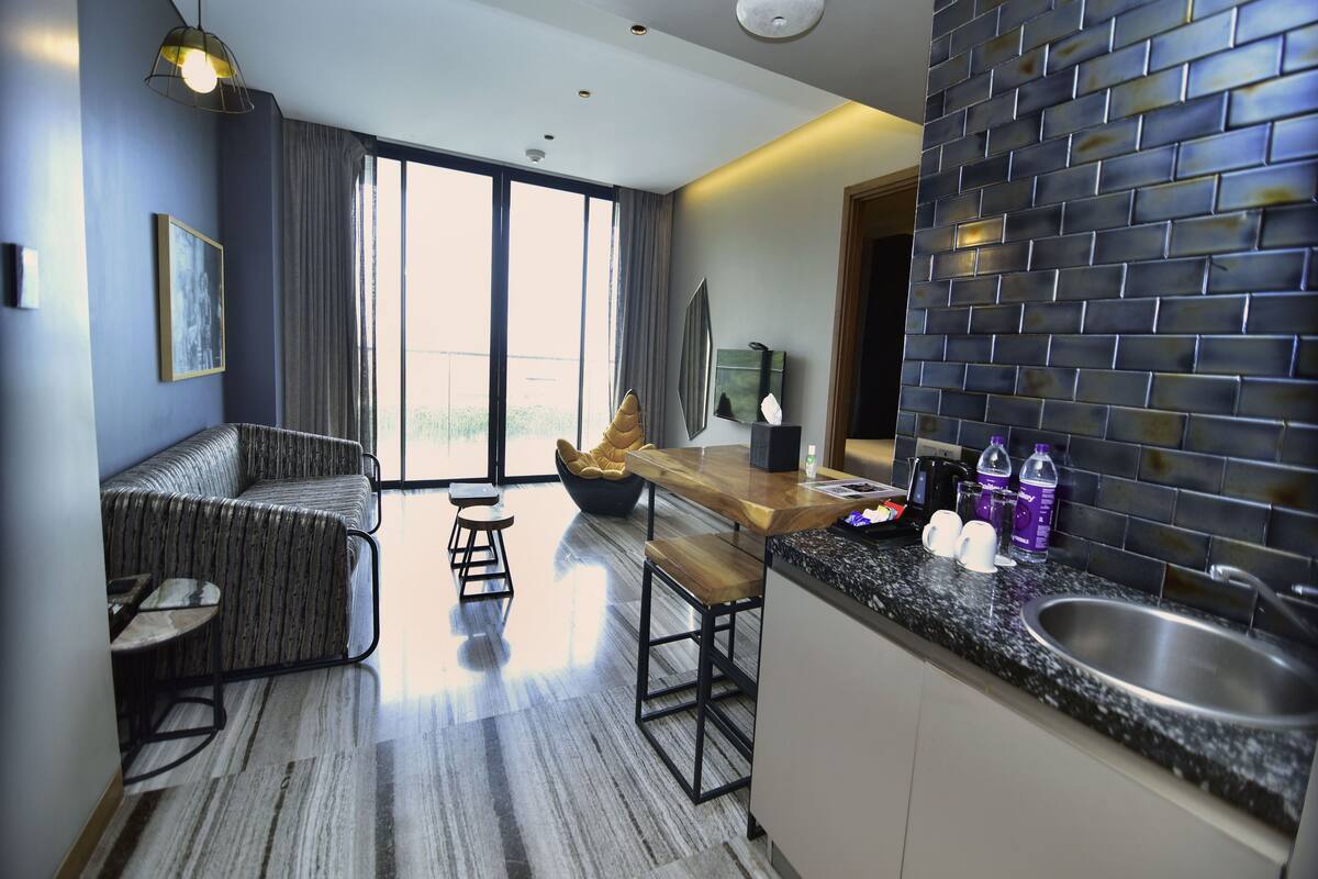 A modern kitchen with a built-in sink, a wooden dining table, and a bar area.