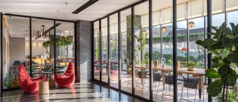 A spacious indoor area with large windows, a polished floor, and modern seating arrangements.