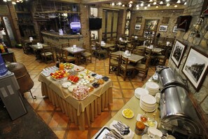 A buffet setup with various food items and a coffee station in a rustic restaurant setting. - Hotel Irmeni (Tbilisi)