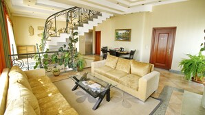 Un amplio salón con sofá, mesa de centro y escalera.