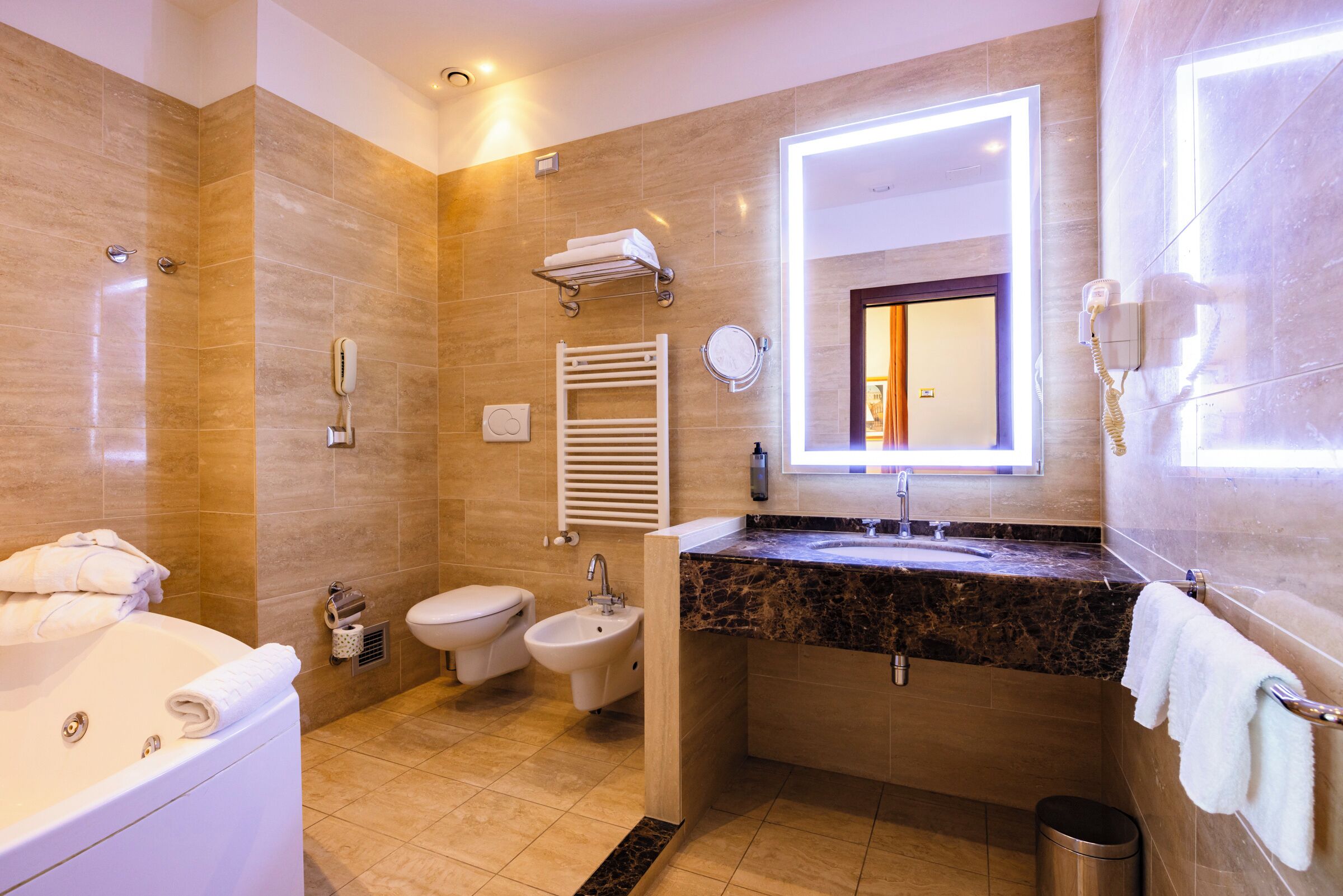 Un baño moderno con bañera, lavamanos, bidé e inodoro.
