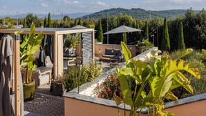 A rooftop terrace with outdoor seating, a pergola, and a view of hills. - Il Gentiluomo Hotel & SPA (Arezzo)