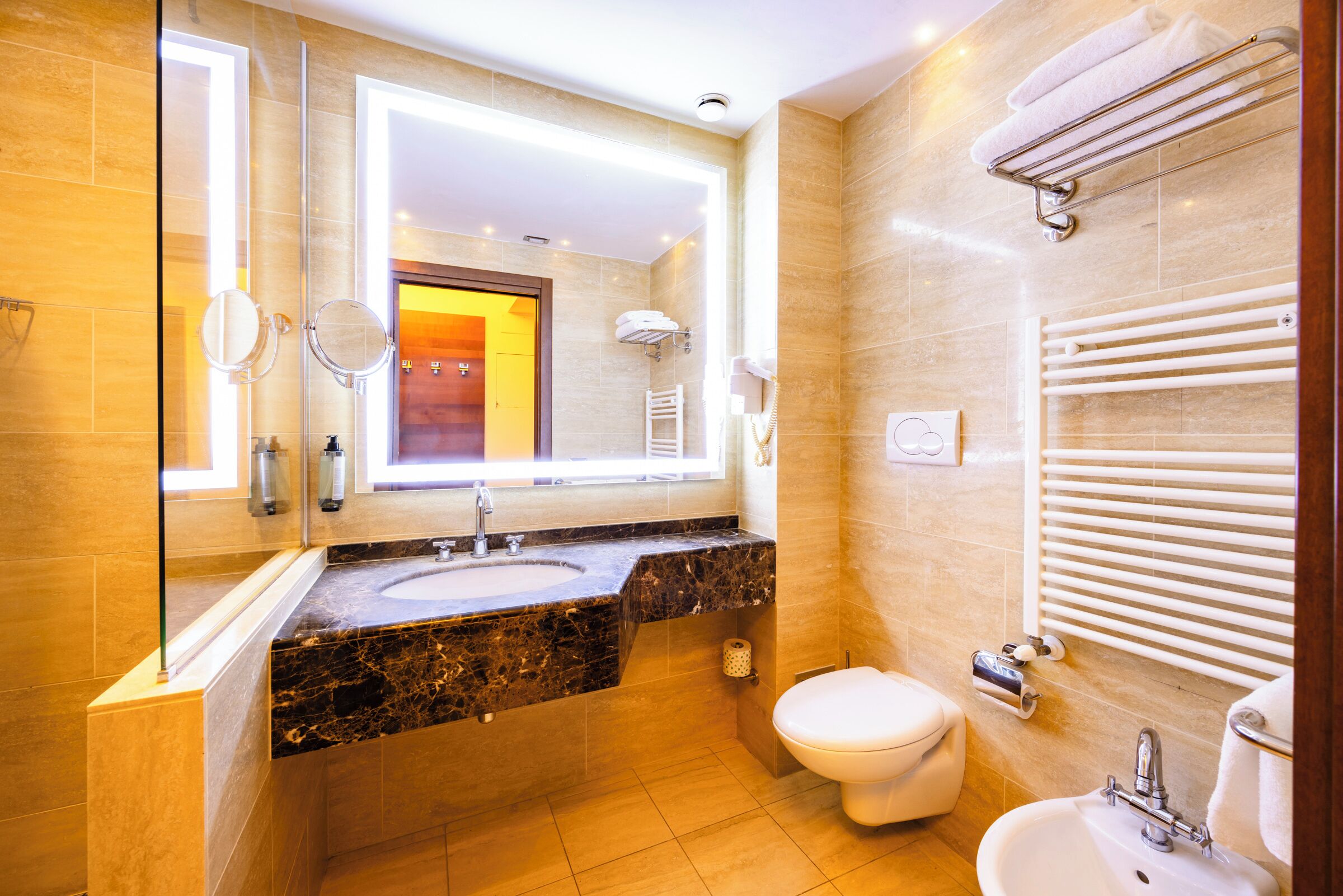 Un bagno moderno con lavandino in marmo, un water e un porta asciugamani.