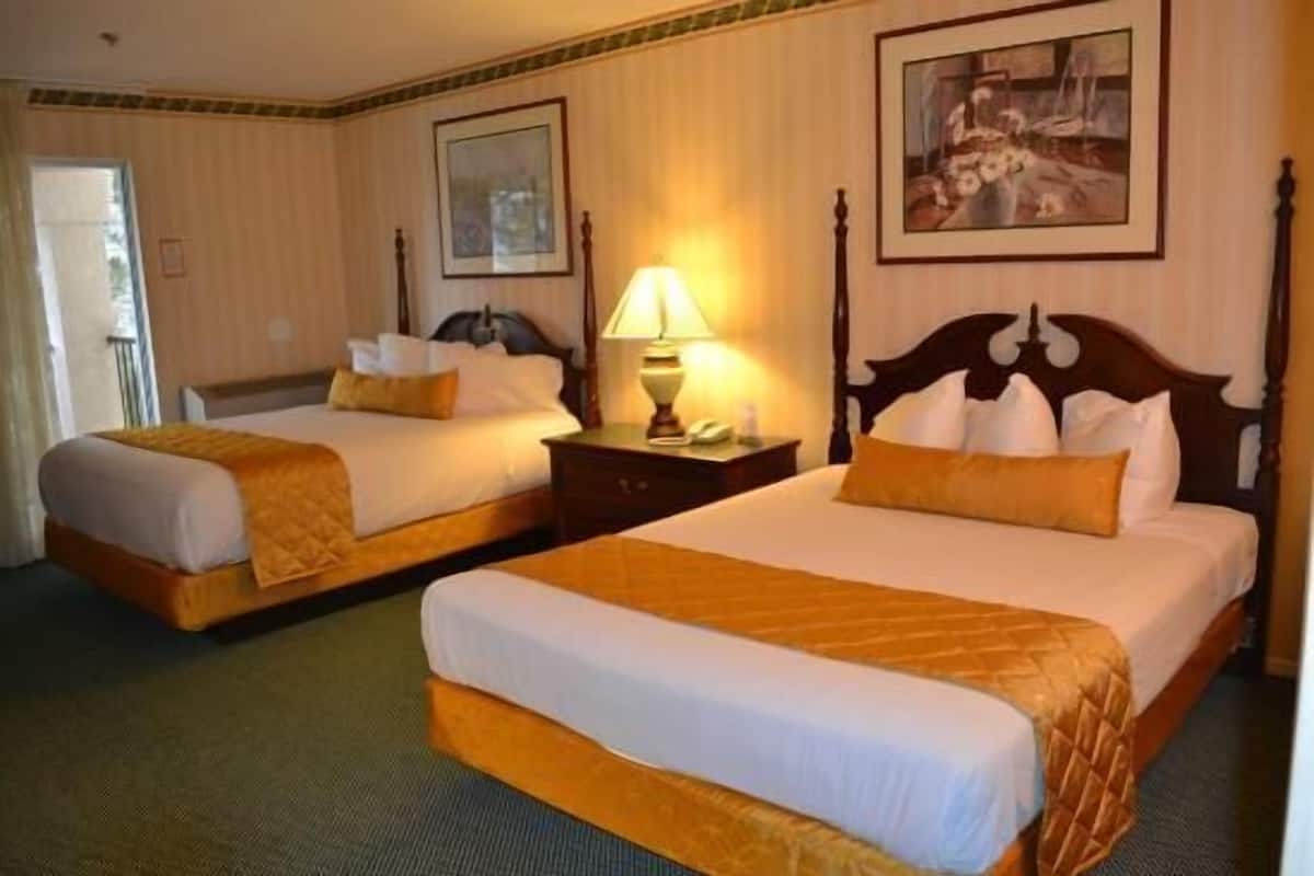 Une chambre d’hôtel avec deux lits, une table de chevet avec une lampe et un tableau au mur.