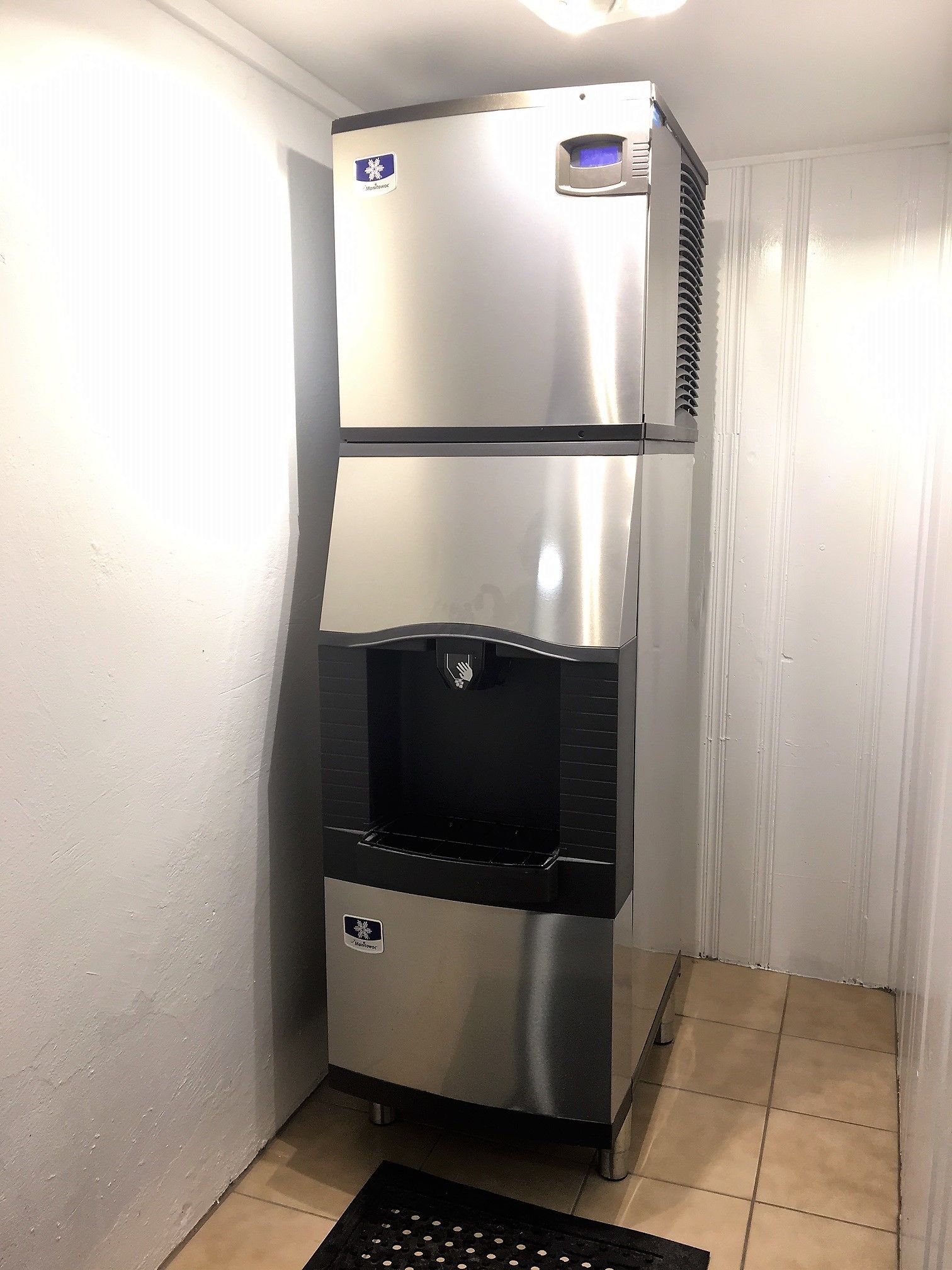 Ein Edelstahl-Kühlschrank mit Wasserspender und digitaler Anzeige.