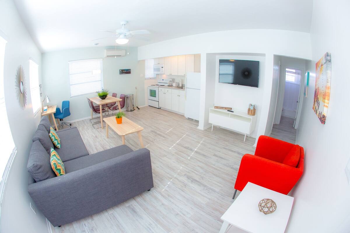 Un appartement moderne comprenant un salon, une cuisine et un coin repas.