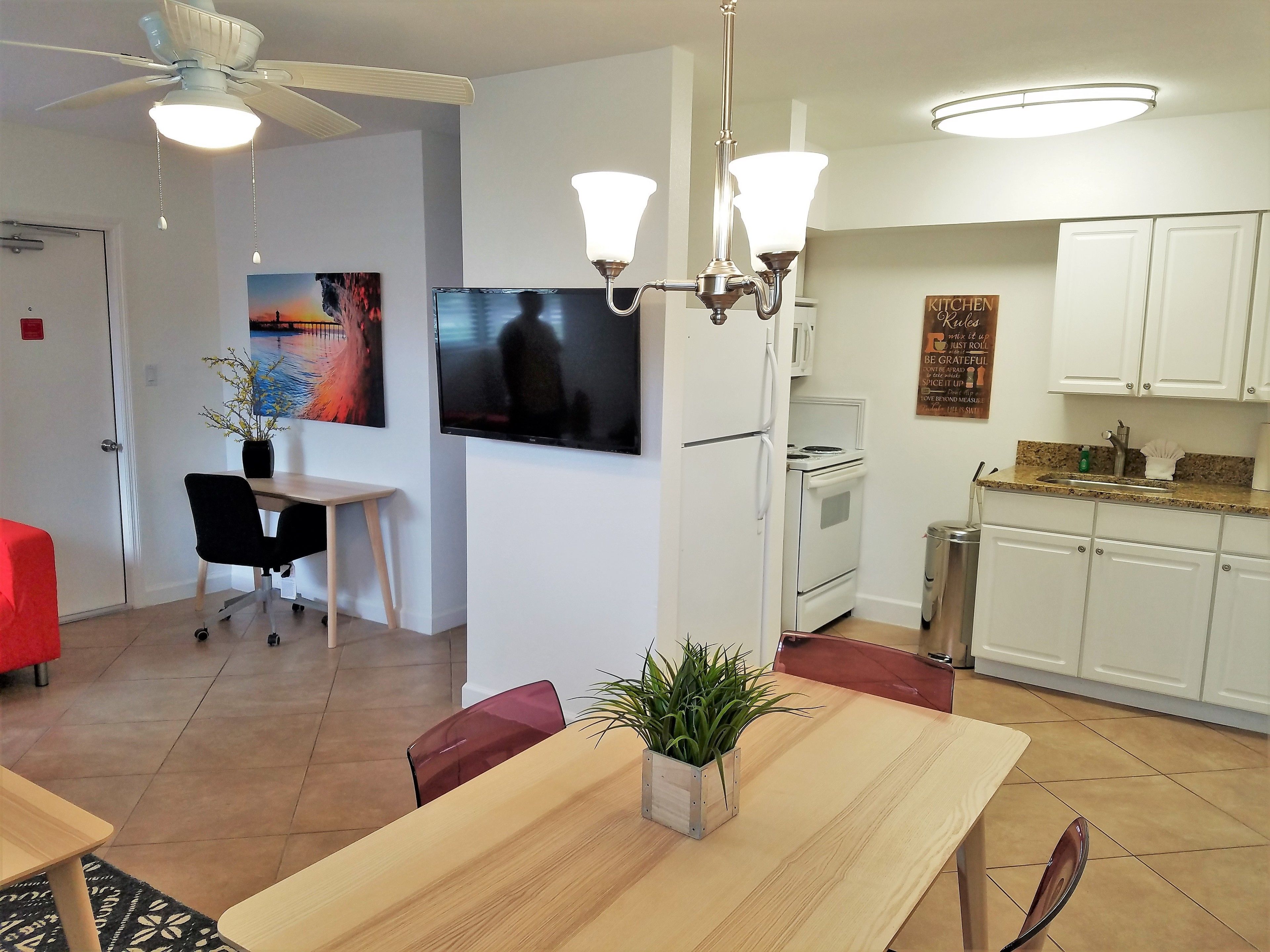 A modern kitchen with white cabinets, a built-in oven, and a stainless steel sink.