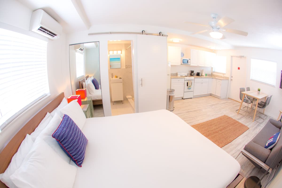 Une chambre d’hôtel moderne dotée d’un grand lit, d’une kitchenette et d’un coin repas.