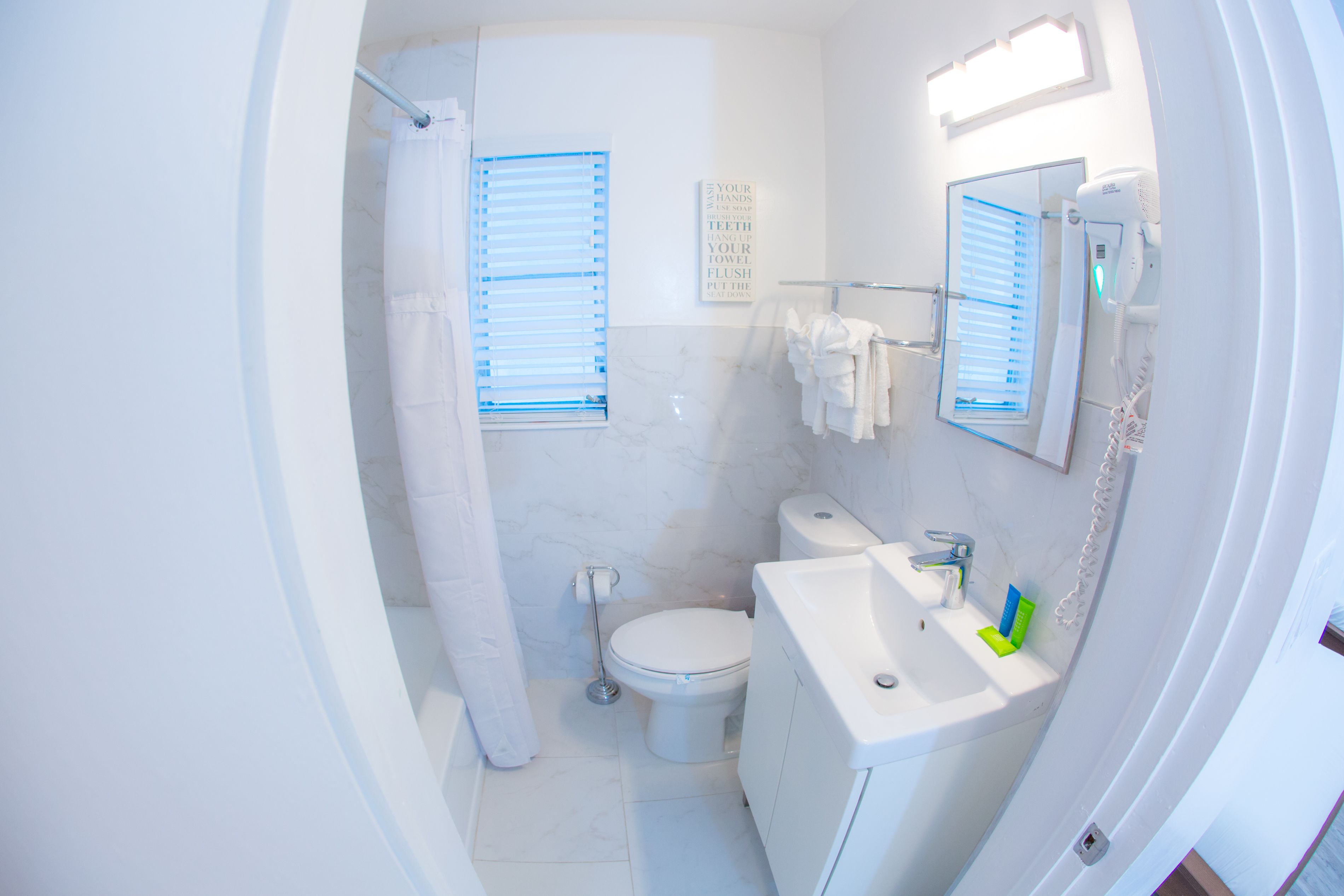 Une salle de bain équipée de toilettes, d’un lavabo et d’un rideau de douche.