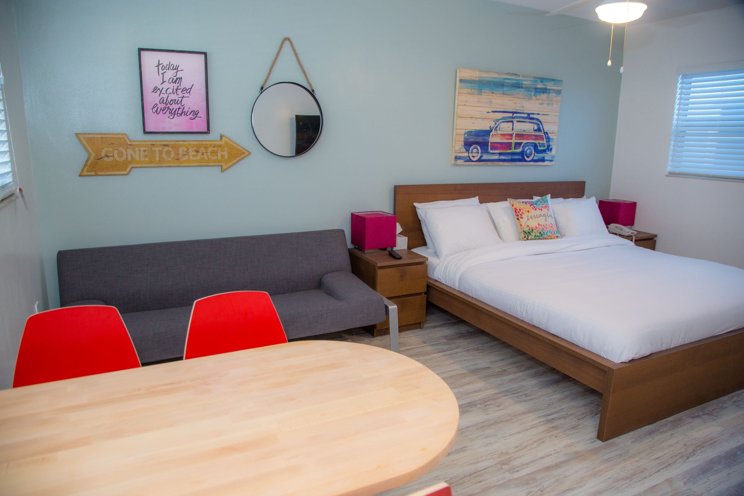 Une chambre à coucher comprenant un lit, un canapé, une table à manger et un miroir.