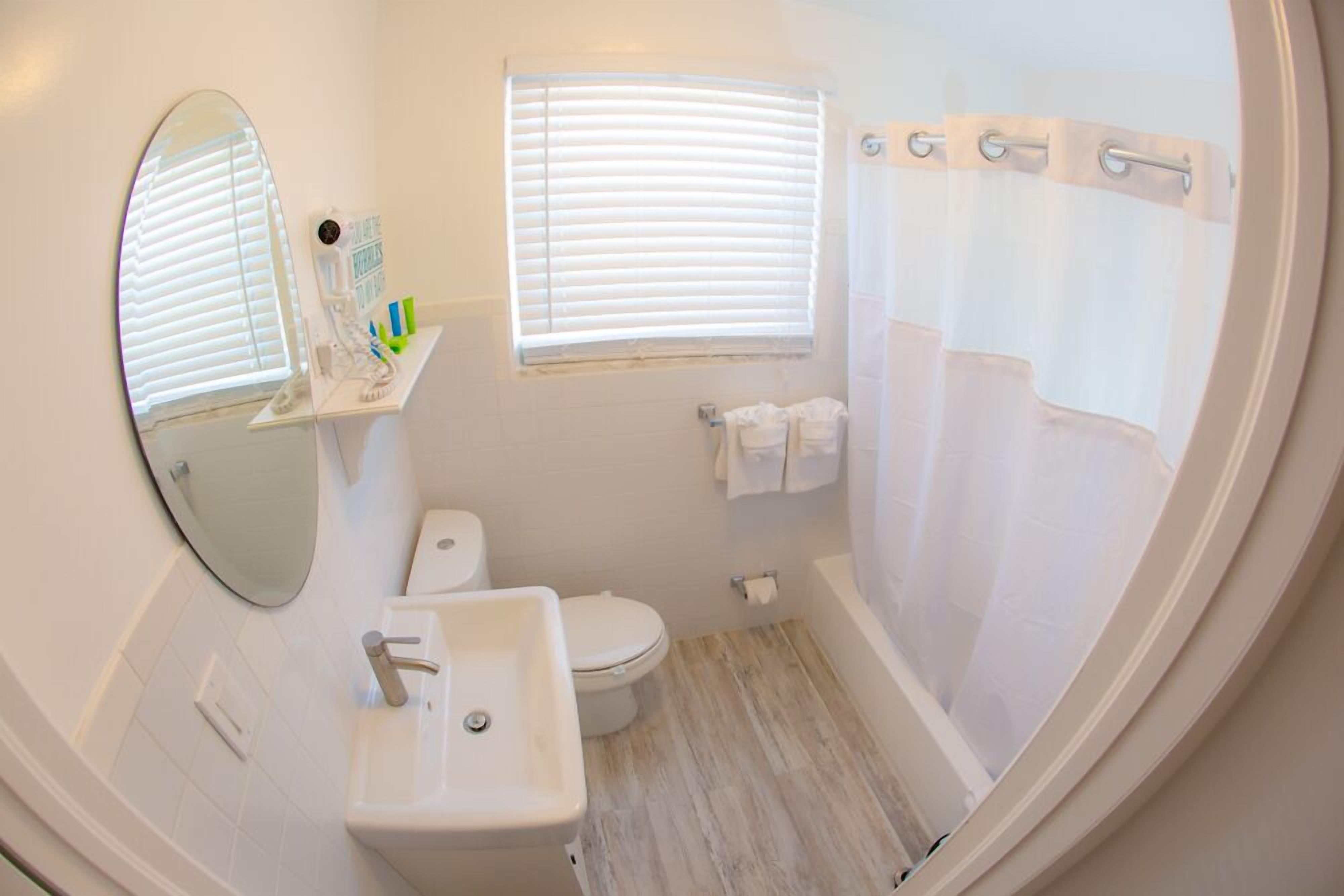 Un baño con inodoro, lavamanos y ducha.