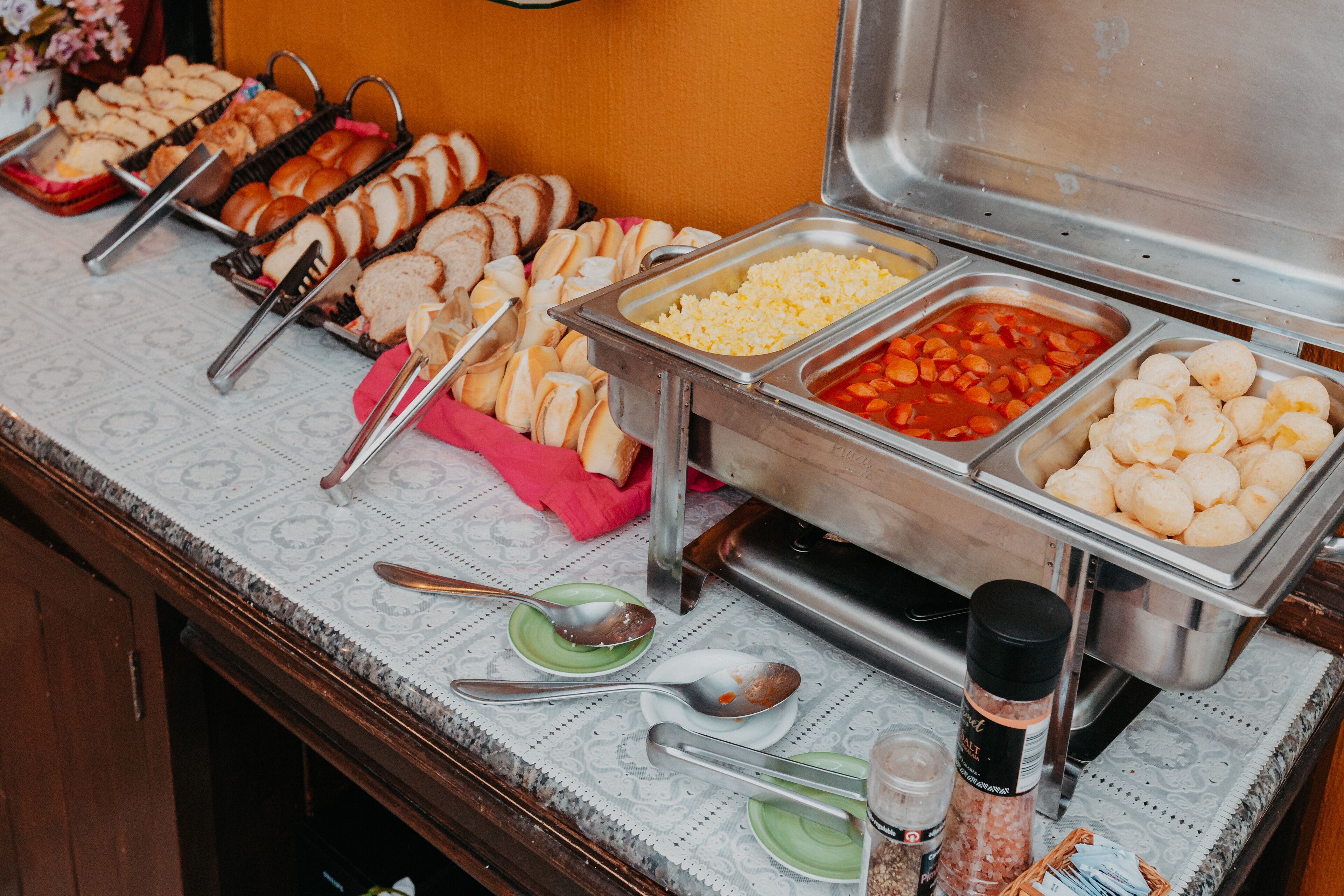 Un buffet proposant une variété de plats, notamment du pain, des œufs et un coin où l’on peut se servir de la soupe.