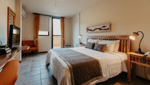 A hotel room with a large bed, a desk with a computer, a chair, and a TV. - Kastel Itaipava Centro Hotel (Petrópolis)