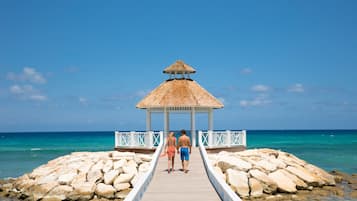 Playa privada, arena blanca, sillas reclinables de playa, sombrillas