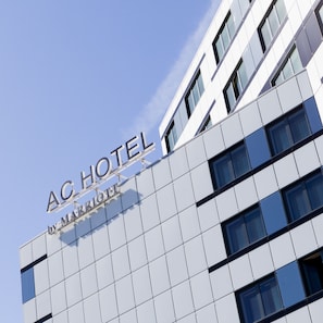 A modern hotel facade with a clear sky.