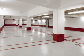 A spacious parking garage with white and red painted lines marking parking spaces.