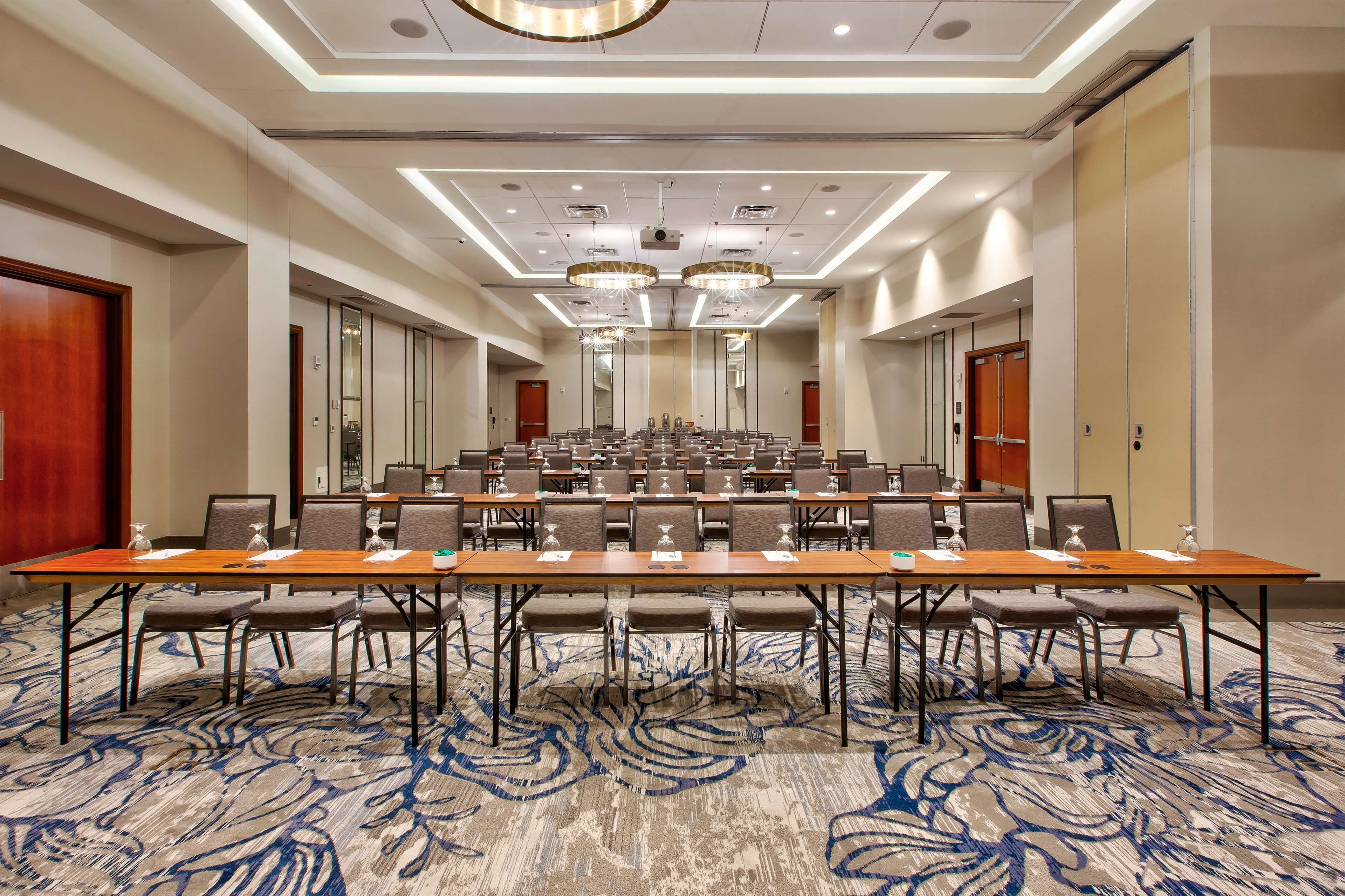 A conference room with a long table, multiple chairs, and a carpeted floor.