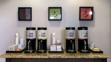 Una estación de café con cinco dispensadores de café: café tostado oscuro, café tostado claro, café descafeinado, agua caliente y una cafetera.