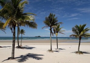 Perto da praia, espreguiçadeiras, guarda-sóis, toalhas de praia