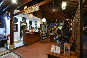 A hotel reception area with a wooden interior, a reception desk, and a sign above it.