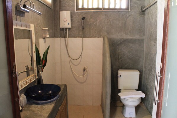 A bathroom with a white toilet, a blue sink, and a shower.