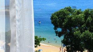 Vista sulla spiaggia con ombrelloni e persone.