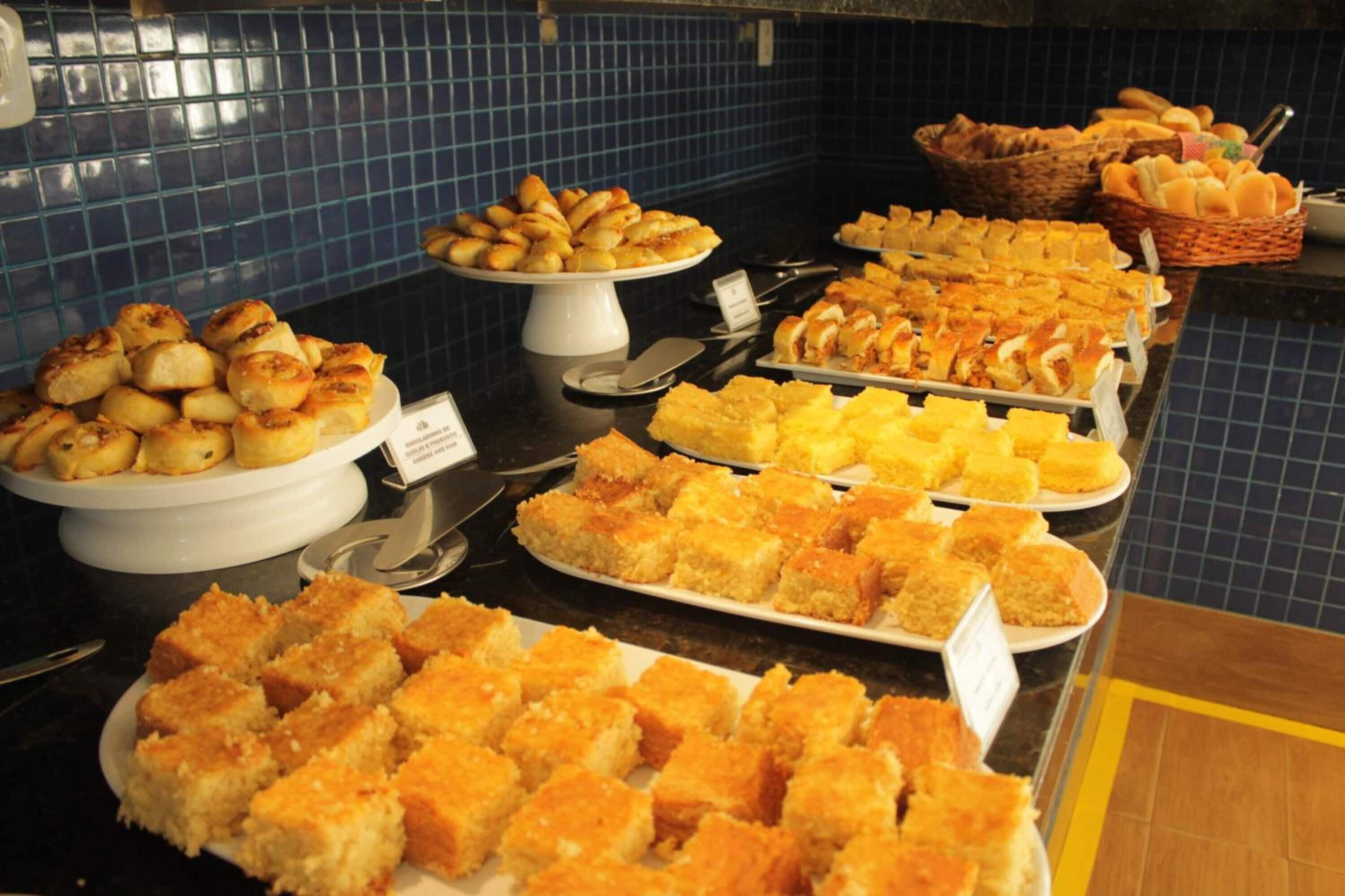 Un buffet proposant une variété de plats, notamment des pâtisseries, du pain et des desserts.
