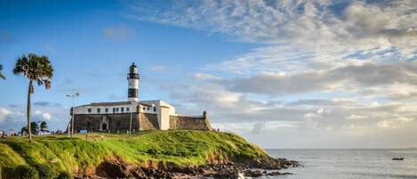 Un fort côtier doté d’un phare, d’une colline herbeuse et d’une côte rocheuse.
