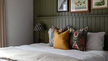 A neatly made bed with patterned pillows and a lamp beside it.