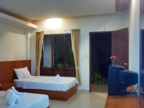 Una habitación de hotel con dos camas, un escritorio y una ventana con cortinas.