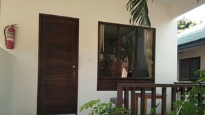 Une porte en bois, une fenêtre et un extincteur fixés au mur.