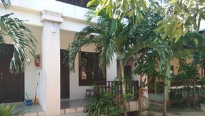 Un immeuble résidentiel doté d’un porche, d’un escalier et de plantes en pot.