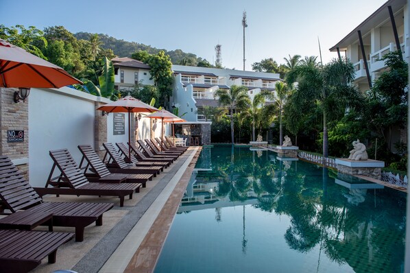 Alberca al aire libre y camastros 